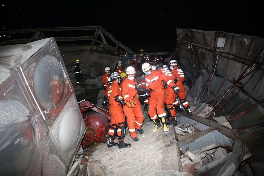 Rescue workers move casualty on the site where a hotel being used for the coronavirus quarantine collapsed, as the country is hit by the novel coronavirus, in Quanzhou March 7, 2020. u00e2u20acu201d cnsphoto via Reuters