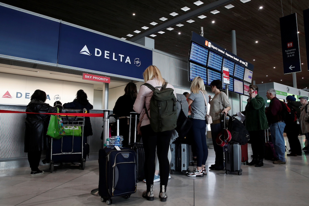 People line up at the Delta Air Lines ticketing desk inside Terminal 2E at Paris Charles de Gaulle airport in Roissy, after the US banned travel from Europe, as France grapples with an outbreak of Covid-19, March 12, 2020. u00e2u20acu201d Reuters pic