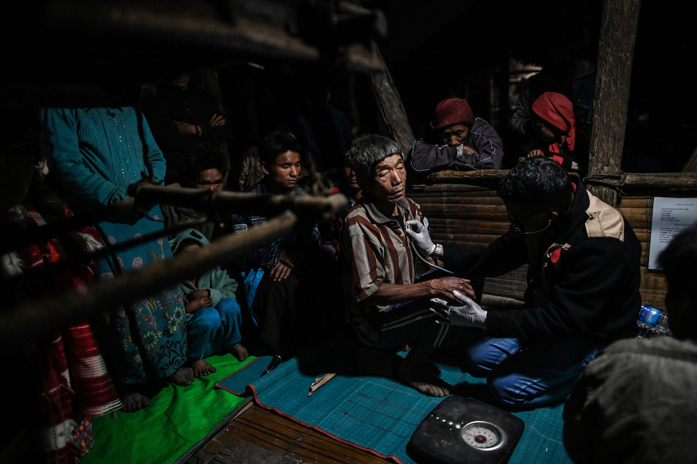 Medical Action Myanmar (MAM) doctor Zaw Min Lay (right) treating a member of a Naga tribe at a mobile clinic in Khar Lay village in Lahel township. u00e2u20acu201d AFP pic
