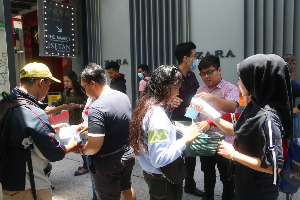 Locals and foreign tourists are seen buying masks from street vendors in front of the Bukit Bintang MRT station in Kuala Lumpur March 16, 2020. u00e2u20acu201d Picture by Choo Choy May