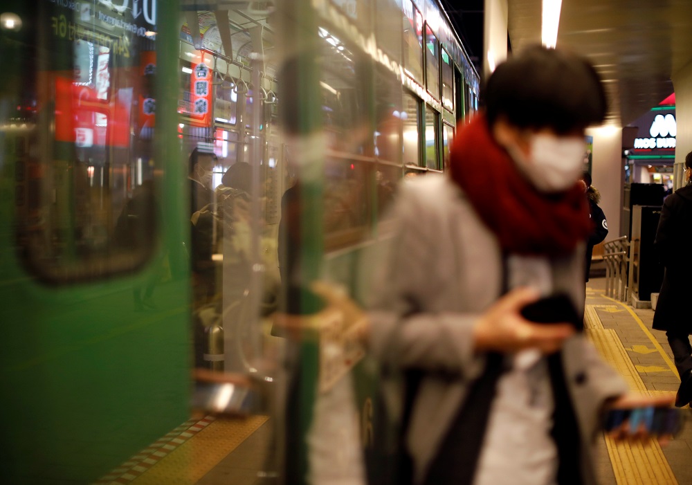 A passenger wearing a protective face mask, following an outbreak of the coronavirus, gets off from a tram in Sapporo, Hokkaido February 25, 2020. u00e2u20acu201d Reuters pic