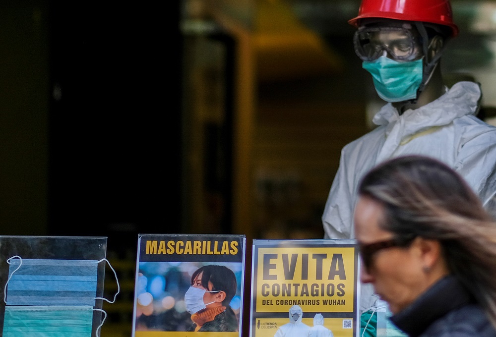 A woman walks past protective face masks at a shop after further cases of coronavirus were confirmed in Barcelona March 6, 2020. The sign (in Yellow) reads u00e2u20acu02dcPrevents infections with coronavirusu00e2u20acu2122. u00e2u20acu201d Reuters pic