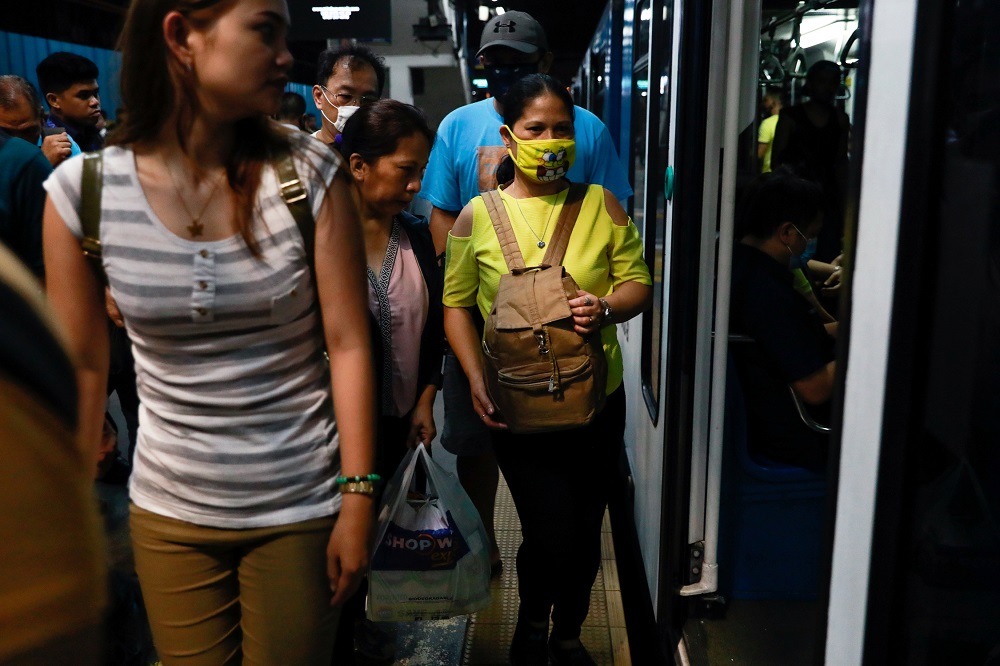 A commuter wearing a protective face mask gets on a train, amid new cases of coronavirus, in Manila March 11, 2020. u00e2u20acu201d Reuters pic