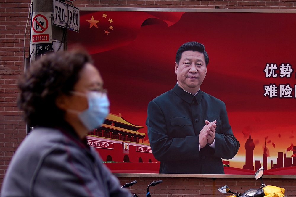 A woman wearing a protective mask is seen past a portrait of Chinese President Xi Jinping on a street as the country is hit by an outbreak of the coronavirus, in Shanghai March 12, 2020. u00e2u20acu201d Reuters pic