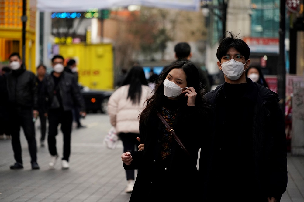 A couple wearing masks to prevent contracting the coronavirus walks in a shopping district in Seoul March 13, 2020. u00e2u20acu201d Reuters pic