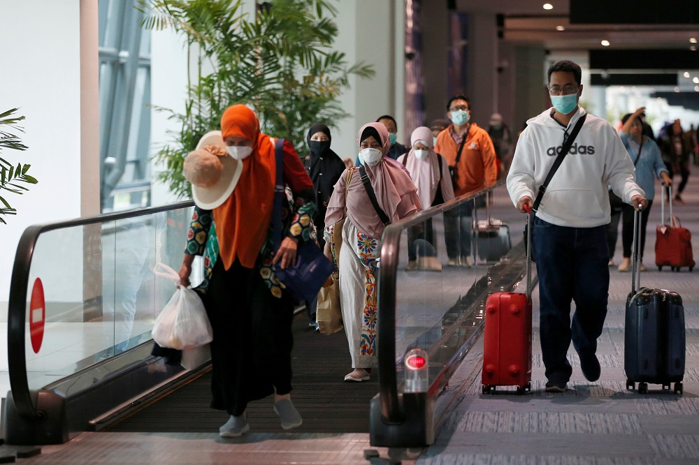 Passengers wearing face masks walk as they arrive at international terminal of Soekarno-Hatta Airport near Jakarta, amid the Covid-19 outbreak March 13, 2020. u00e2u20acu201d Reuters pic
