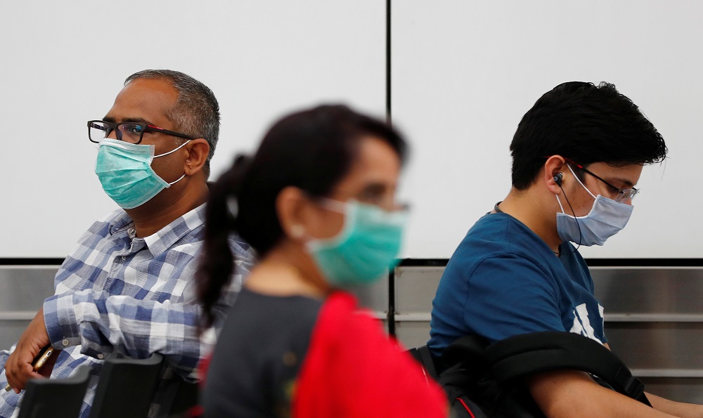 Passengers wearing protective masks sit at an airport terminal following an outbreak of the coronavirus disease, in New Delhi March 14, 2020. u00e2u20acu201d Reuters pic