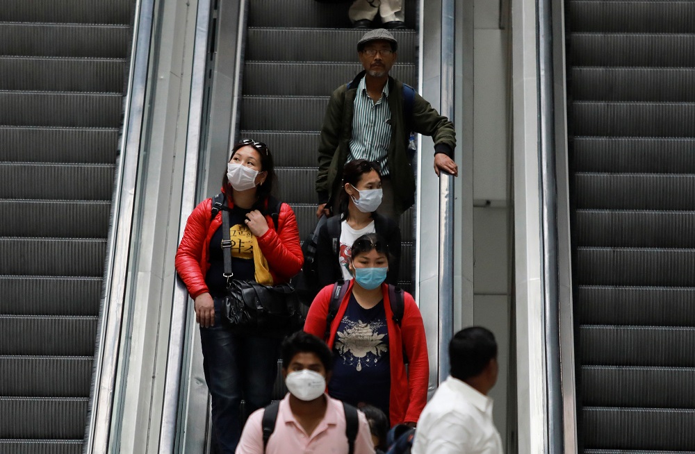Passengers wearing protective masks travel on an escalator at an airport terminal following an outbreak of the coronavirus disease, in New Delhi March 14, 2020. u00e2u20acu201d Reuters pic
