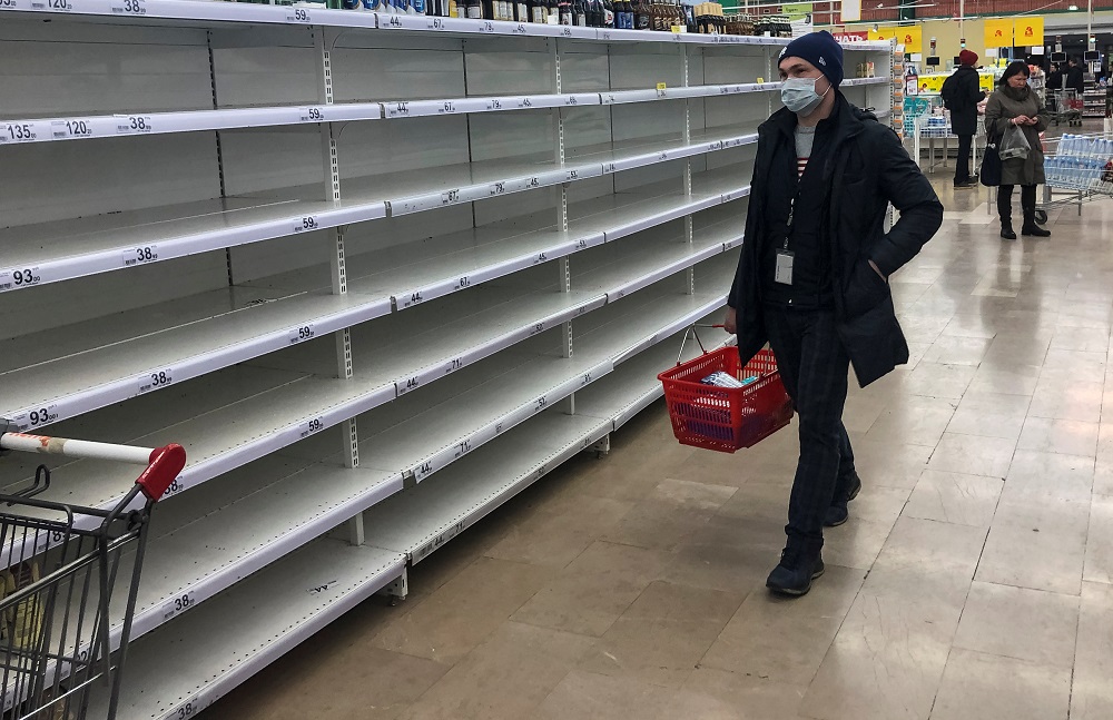 A man, wearing a protective mask, walks past empty shelves in a store, due to the fear of Covid-19 outbreak in Moscow March 17, 2020. u00e2u20acu201d Reuters pic