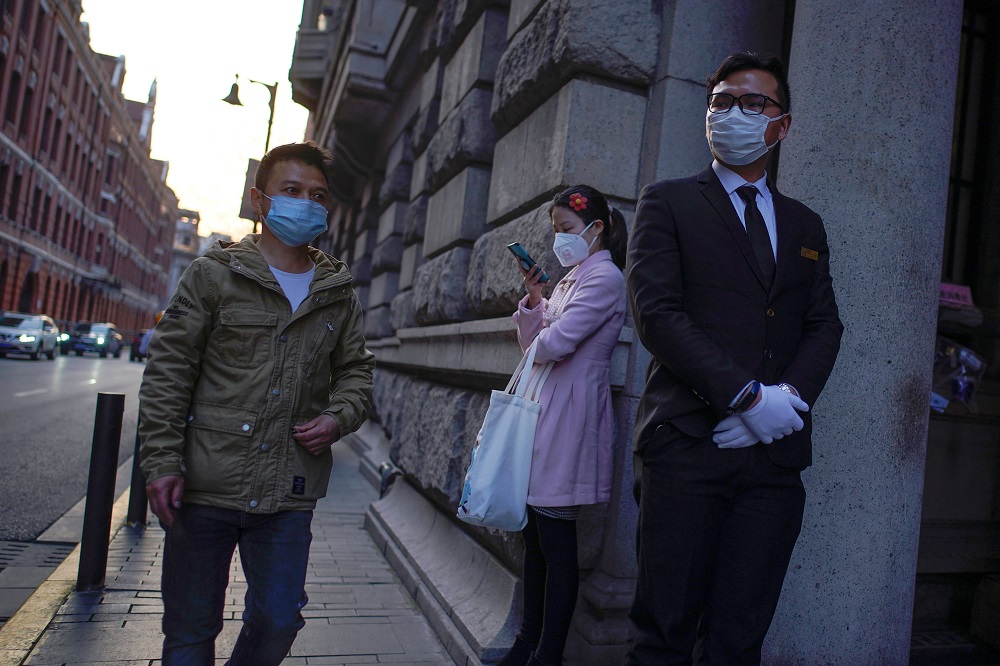 People wearing protective face masks are seen on a street, following an outbreak of Covid-19, in Shanghai March 18, 2020. u00e2u20acu201d Reuters pic