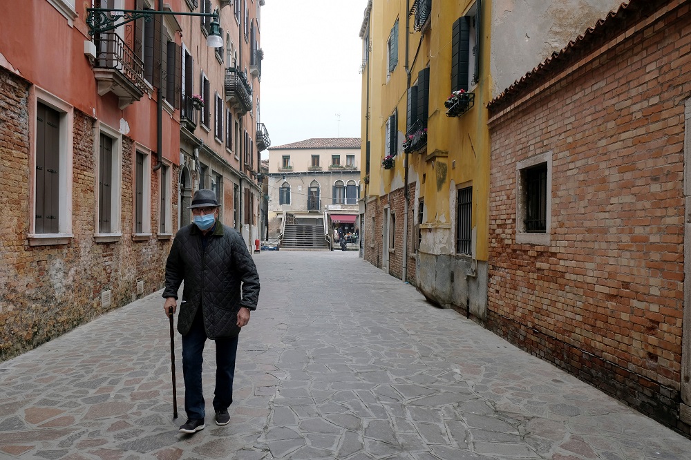 An elderly man with a protective mask walks in Venice, on the fourth day of an unprecedented lockdown across all country, imposed to slow the outbreak of coronavirus, in Italy March 13, 2020. u00e2u20acu201d Reuters pic