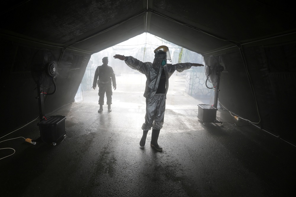 A worker wearing protective suits is sprayed with disinfectant to prevent the spread of coronavirus disease in Banda Aceh March 26, 2020. u00e2u20acu201d Picture by Antara Foto via Reuters