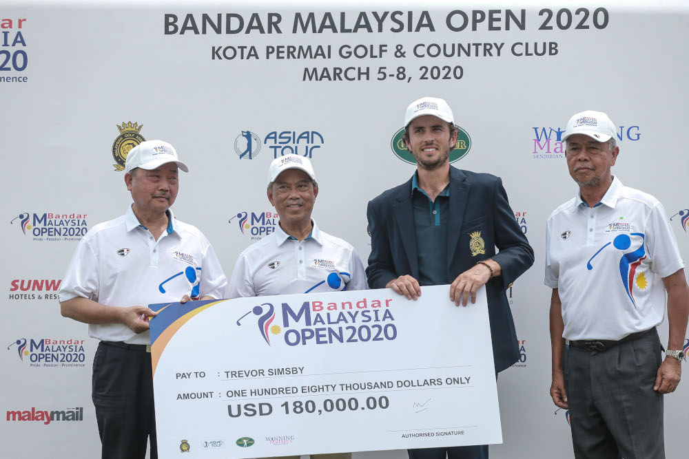 Prime Minister Tan Sri Muhyiddin Yassin presents a cheque to Travor Simsby after he won the Bandar Malaysia 2020 Open at Kota Permai Golf and Country Club March 8, 2020. u00e2u20acu201d Picture by Ahmad Zamzahuri