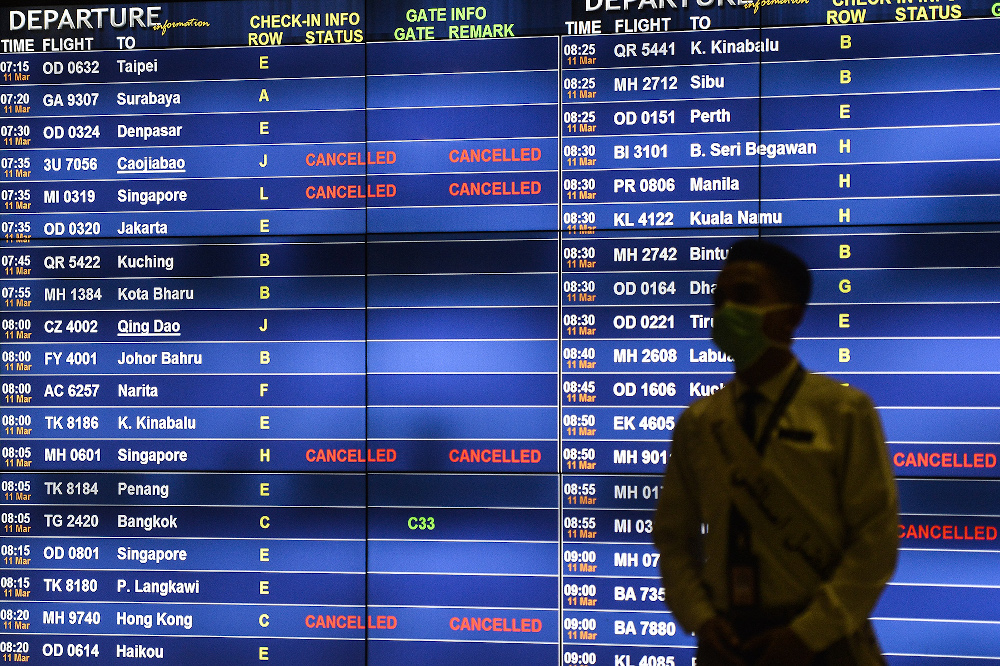 Passengers watching a departure screen at KLIA March 10, 2020. u00e2u20acu201d Picture by Miera Zulyana