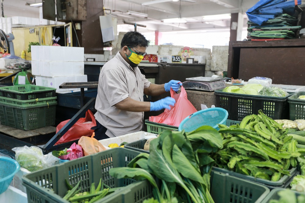 A vegetable trader is seen arranging fresh produce at a wet market in Petaling Jaya March 25,2020.  u00e2u20acu201d Picture by Ahmad Zamzahuri
