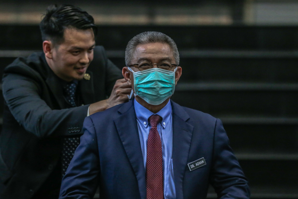 Health Minister Datuk Seri Dr Adham Baba demonstrates the correct way to wear a face mask after a press conference at Hospital Sg Buloh March 12, 2020. — Picture by Firdaus Latif