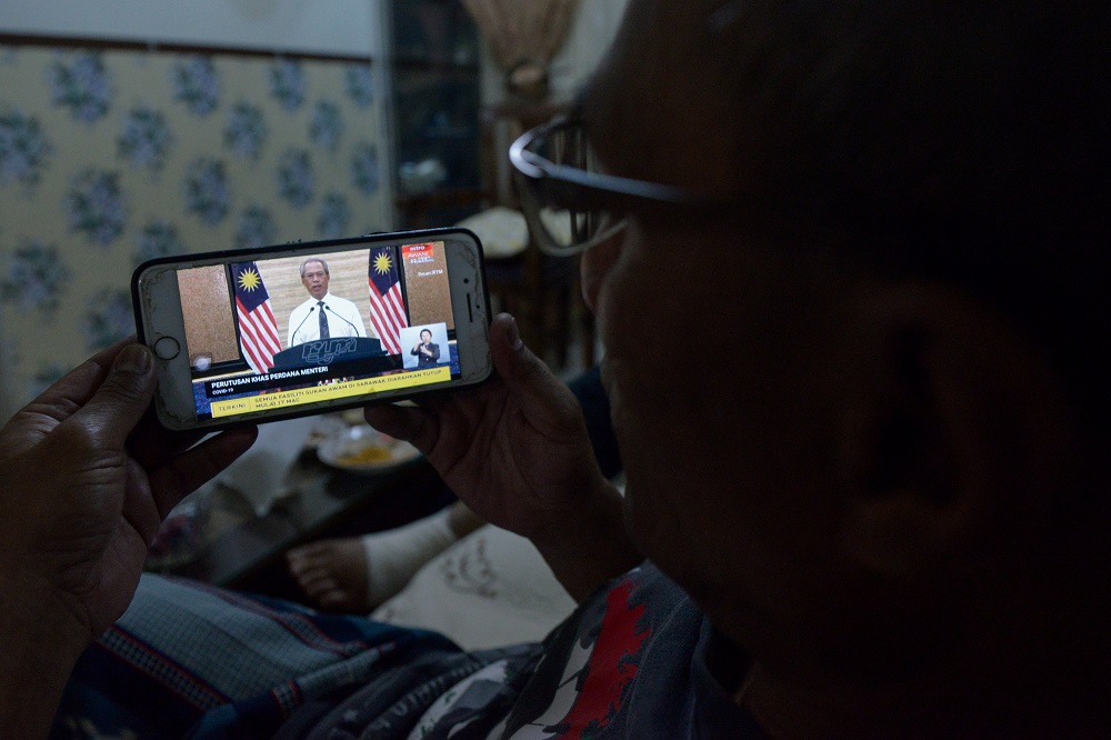 People watching the live telecast of Prime Minister Tan Sri Muhyiddin Yassinu00e2u20acu2122s announcement of a movement control order due to the Covid-19 pandemic in Kuala Lumpur March 16, 2020. u00e2u20acu201d Picture by Miera Zulyana