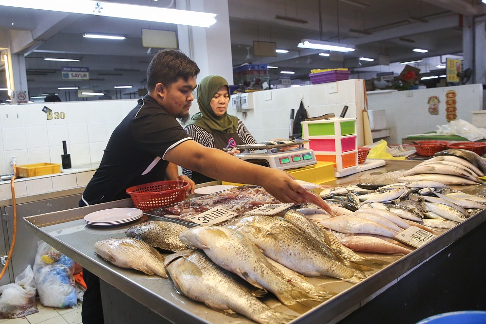 Shazwan Aiman arranges fresh fish at his stall at the SS15 wet market in Subang Jaya March 18, 2020. — Picture by Yusof Mat Isa