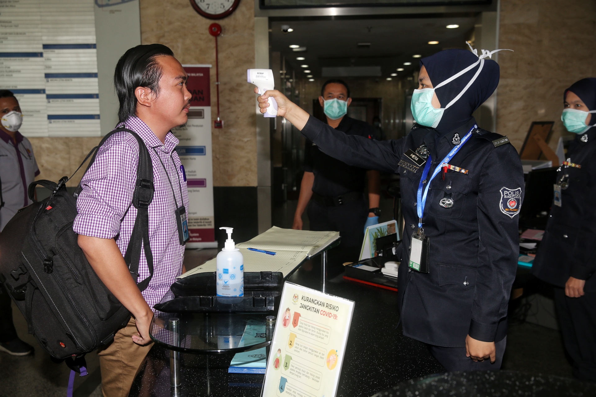 A police personnel records a reporteru00e2u20acu2122s temperature ahead of a Health Ministry press conference in Putrajaya March 19, 2020. u00e2u20acu201d Picture by Choo Choy May