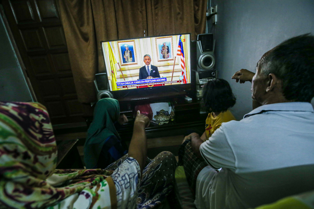 People watch a live telecast of Yang di-Pertuan Agong Al-Sultan Abdullah Ri'ayatuddin Al-Mustafa Billah Shah regarding the movement control order due to the Covid-19 pandemic in Kuala Lumpur March 20, 2020. u00e2u20acu201d Picture by Hari Anggara