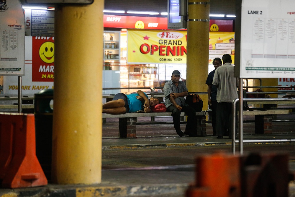 A few homeless people are seen seeking shelter at a bus stop near the Komtar building in George Town March 20, 2020. u00e2u20acu201d Picture by Sayuti Zainudin