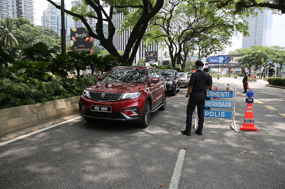 Police personnel inspect vehicles at a roadblock on Jalan Ampang in Kuala Lumpur March 21, 2020. u00e2u20acu201d Picture by Yusof Mat Isa