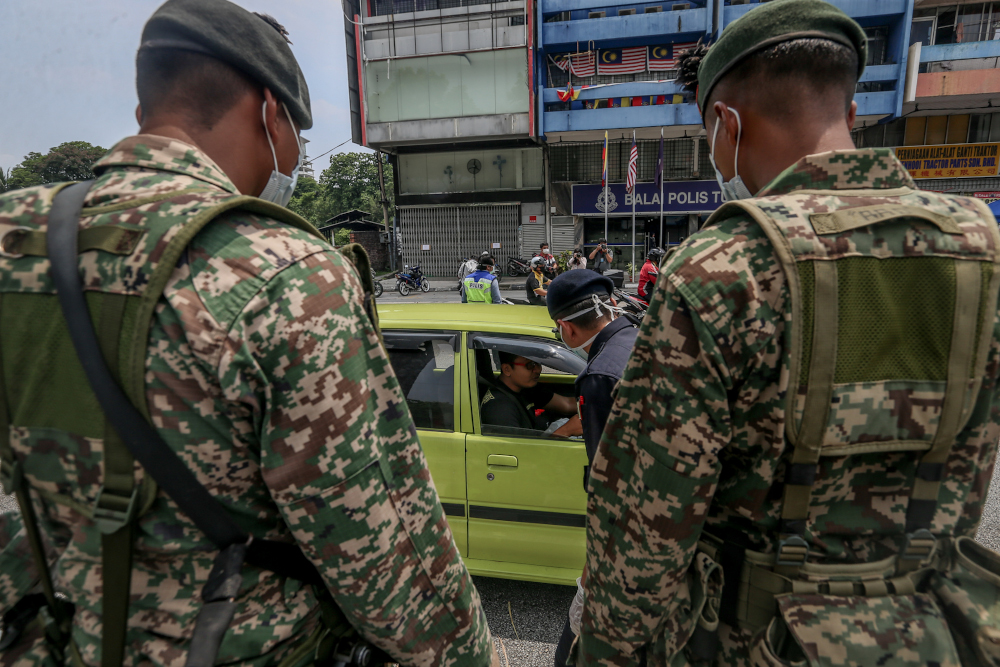Soldiers and police officers conducting checks at a roadblock on day five of the movement control order (MCO) at Jalan Loke Yew in Kuala Lumpur March 22, 2020. u00e2u20acu201d Picture by Firdaus Latif