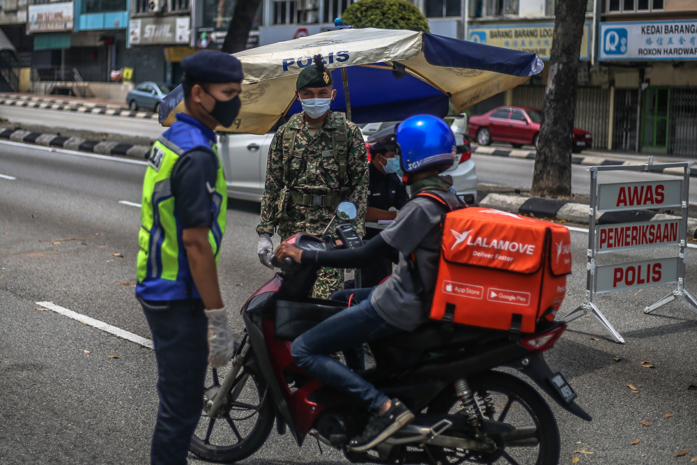 Soldiers and police officers conducting checks at a roadblock on day five of the movement control order (MCO) at Jalan Loke Yew in Kuala Lumpur March 22, 2020. u00e2u20acu201d Picture by Firdaus Latif