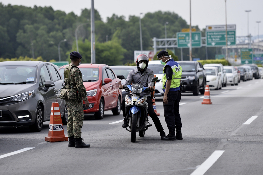 Soldiers and police officers conducting checks at a roadblock in Bukit Jelutong, Shah Alam March 22,2020. u00e2u20acu201d Picture by Miera Zulyana