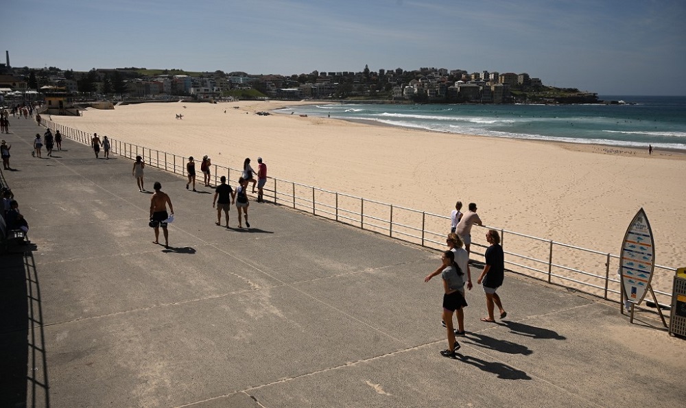 People walk past an empty Bondi Beach after authorities closed Sydney’s most popular beach March 22, 2020. — AFP pic