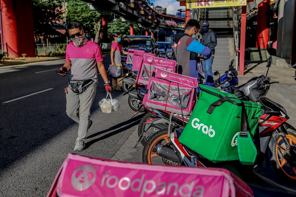 FoodPanda food delivery riders are seen outside an eatery in Kuala Lumpur March 25, 2020. u00e2u20acu201d Picture by Firdaus Latif
