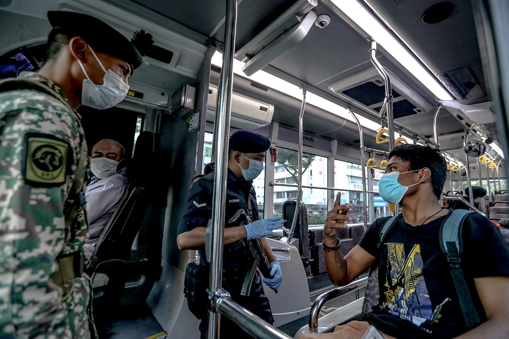 Malaysian Armed Forces and police personnel conduct a routine check on bus passengers at a roadblock in Kuala Lumpur March 25, 2020. u00e2u20acu201d Picture by Firdaus Latif