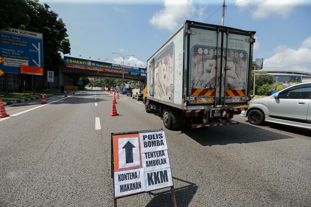 A sign indicating the designated lane for frontliners is seen at a roadblock in Kuala Lumpur March 28, 2020. u00e2u20acu201d Picture by Ahmad Zamzahuri