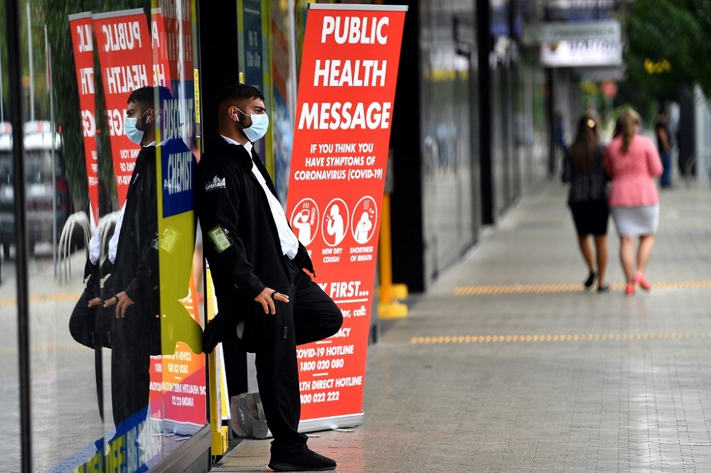 A security guard with a face mask stands outside a pharmacy in Sydney March 27, 2020. u00e2u20acu201d AFP pic