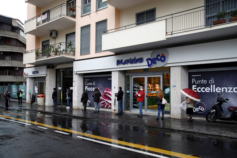 People line up in the rain outside a supermarket after the Italian island of Sicily closed them on Sunday, as it tightens measures to try and contain the spread of coronavirus disease (COVID-19), in Catania, Italy March 23, 2020. u00e2u20acu201d Reuters pic