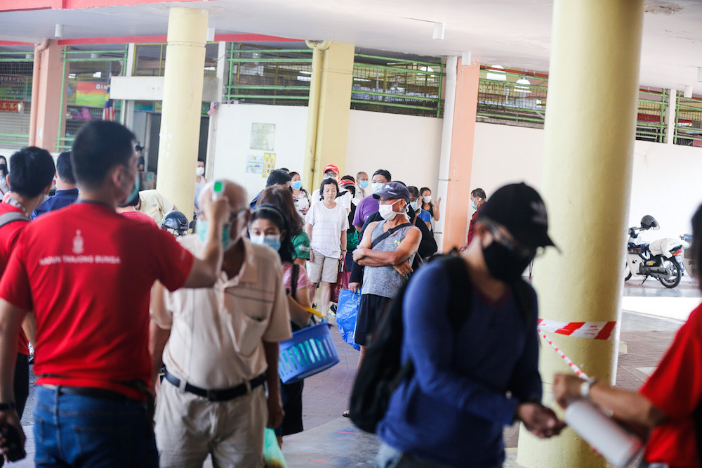 Members of the public are seen adhering to ‘social distancing’ guidelines as they buy groceries at Tanjung Bungah wet market, March 22, 2020. Picture by Sayuti Zainudin