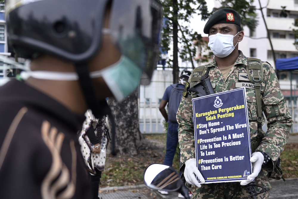 Soldiers and police officers conducting checks at a roadblock on day five of the movement control order (MCO) in Sri Hartamas March 22,2020. u00e2u20acu201d Picture by Miera Zulyana
