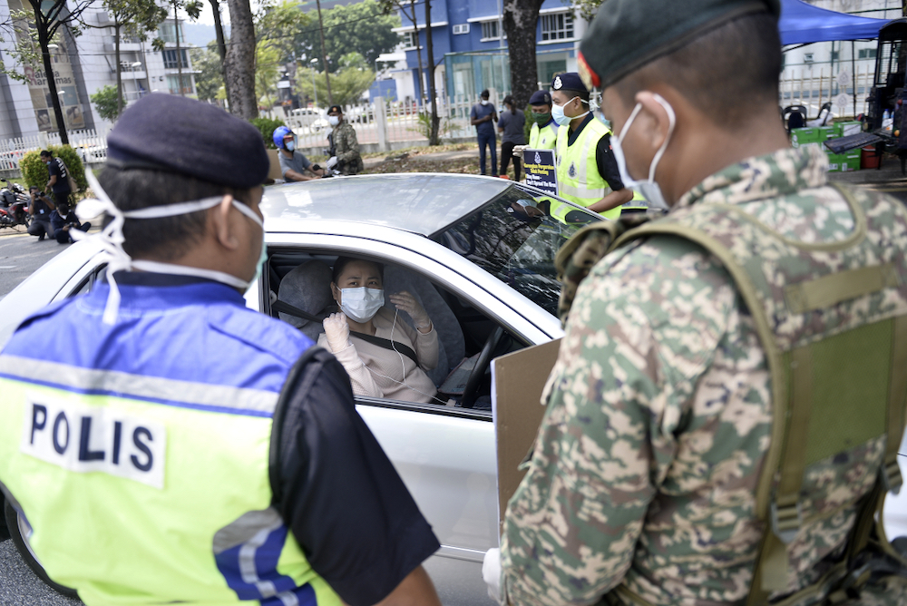 Soldiers and police officers conducting checks at a roadblock on day five of the movement control order (MCO) in Sri Hartamas March 22,2020. u00e2u20acu201d Picture by Miera Zulyana