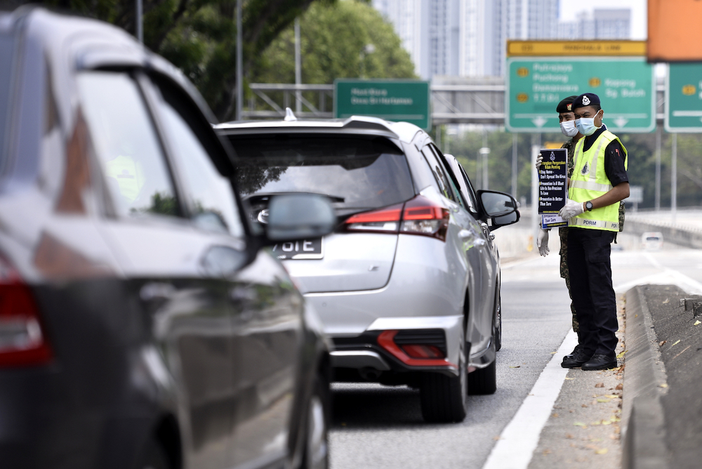 Soldiers and police officers conducting checks at a roadblock on day five of the movement control order (MCO) in Sri Hartamas March 22,2020. u00e2u20acu201d Picture by Miera Zulyana