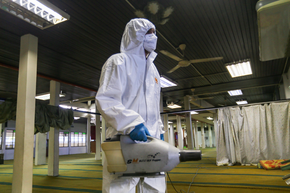 A worker sprays disinfectant in a mosque to prevent the spread of the novel coronavirus in Kuala Lumpur March 23, 2020. u00e2u20acu201d Picture by Firdaus Latif 
