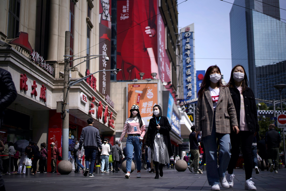 People wear masks at a main shopping area after the city's emergency alert level for coronavirus disease (Covid-19) was downgraded, in Shanghai March 23, 2020. u00e2u20acu201d Reuters pic