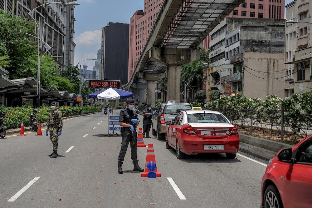 Soldiers and police officers conducting checks at a roadblock during the movement control order (MCO) in Kuala Lumpur March 29, 2020. u00e2u20acu201d Picture by Firdaus Latif