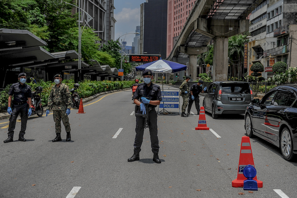 Soldiers and police officers conducting checks at a roadblock during the movement control order (MCO) in Kuala Lumpur March 29, 2020. u00e2u20acu201d Picture by Firdaus Latif