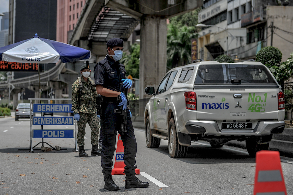 Soldiers and police officers conducting checks at a roadblock during the movement control order (MCO) in Kuala Lumpur March 29, 2020. u00e2u20acu201d Picture by Firdaus Latif