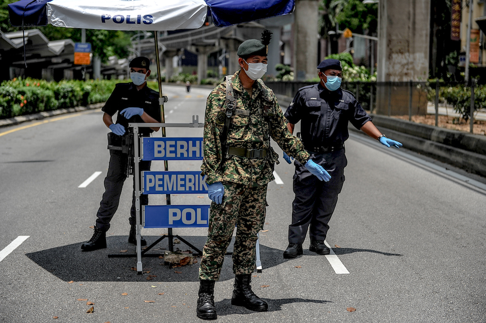 Soldiers and police officers conducting checks at a roadblock during the movement control order (MCO) in Kuala Lumpur March 29, 2020. u00e2u20acu201d Picture by Firdaus Latif