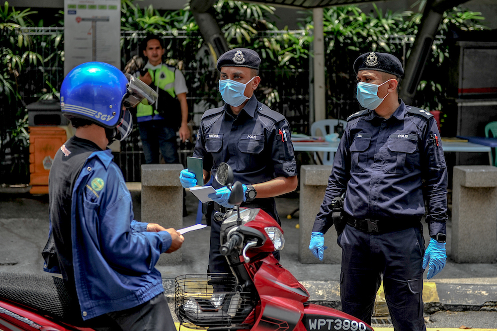 Soldiers and police officers conducting checks at a roadblock during the movement control order (MCO) in Kuala Lumpur March 29, 2020. u00e2u20acu201d Picture by Firdaus Latif