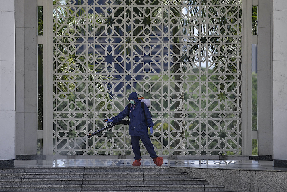 A worker sprays disinfectant in a mosque as a precaution against the spread of Covid-19, Shah Alam March 29, 2020. u00e2u20acu201d Picture by Miera Zulyana