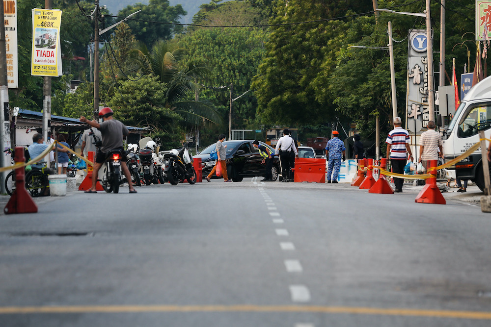 Policemen and personnel from the MBPP enforcement unit, civil defence and army are seen controlling traffic near the Air Itam market, 30 March, 2020. u00e2u20acu201d Picture by Sayuti Zainudin