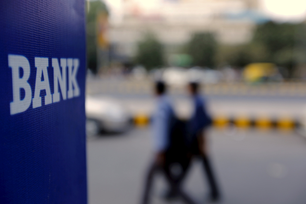 Commuters walk past a bank sign along a road in New Delhi, India November 25, 2015. Under the plan, there would likely be only one bank branch open every five km in major cities. u00e2u20acu201d Reuters pic 