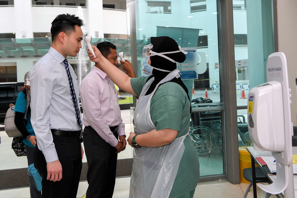 A hospital staff takes the temperature of visitors arriving at the Pantai Hospital in Kuala lumpur March 3, 2020. u00e2u20acu201d Bernama pic